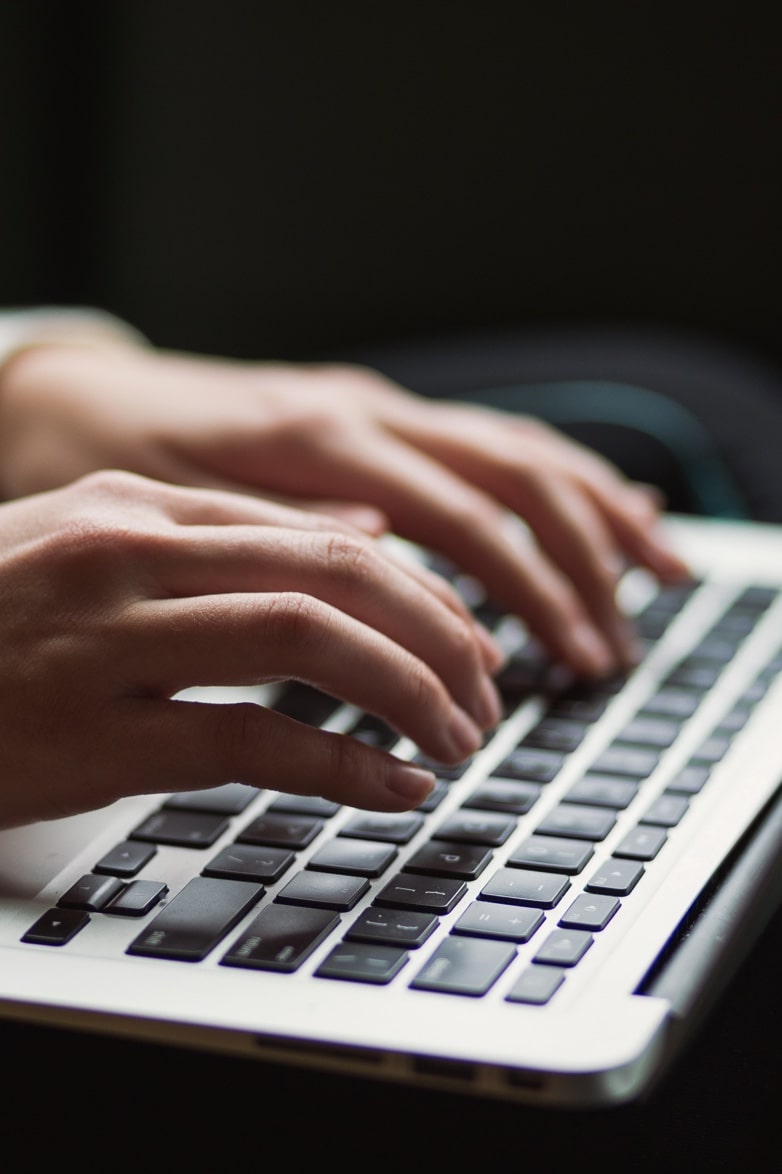 Close-up of hands typing on a laptop computer